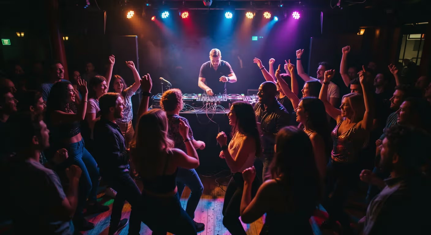 DJ playing first gig at small venue with dancing crowd